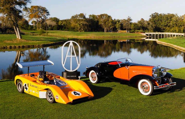 An orange Can-Am McLaren and a prewar speedster flanking the Amelia trophy beside the lake at the Amelia Island Concours d’Elegance, an engagement in the season calendar of The Mansa Court