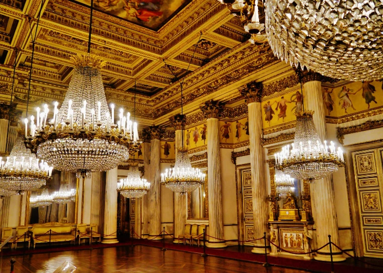 Tiers of crystal chandeliers under the coffered gold ceiling of the Royal Palace of Turin’s ballroom (2020).