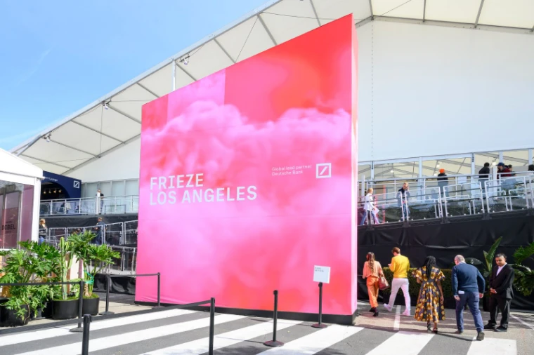 Visitors arriving past the pink entrance wall of the fair tent at Frieze Los Angeles, an engagement in the season calendar of The Mansa Court
