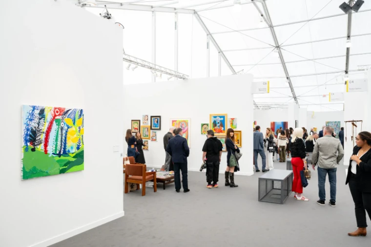 Paintings hung along the white walls of a gallery aisle under the daylit tent at Frieze Los Angeles, an engagement in the season calendar of The Mansa Court