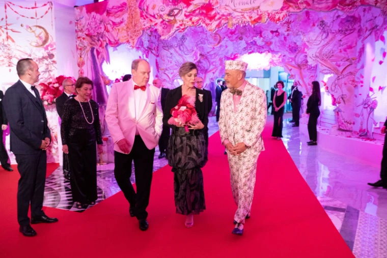 Guests in black tie arriving along the red carpet beneath a painted rose canopy at Le Bal de la Rose, Salle des Étoiles, Monte Carlo, an engagement in the season calendar of The Mansa Court