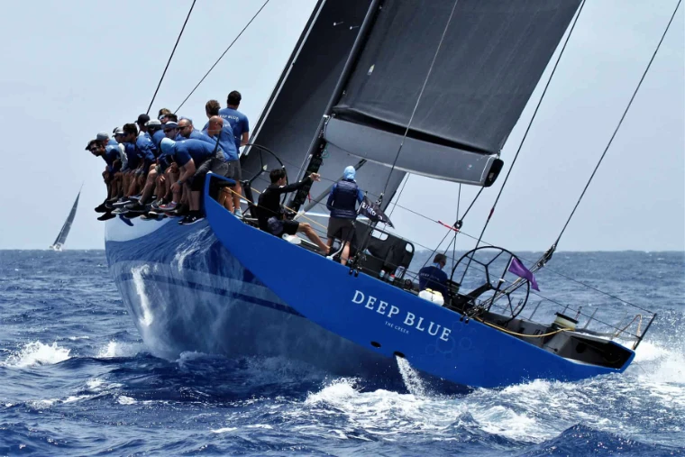 The crew of Deep Blue hiked out on the high side as she heels hard through the swell at Les Voiles de Saint-Barth, St. Barthélemy, a mid-April engagement in the season calendar of The Mansa Court