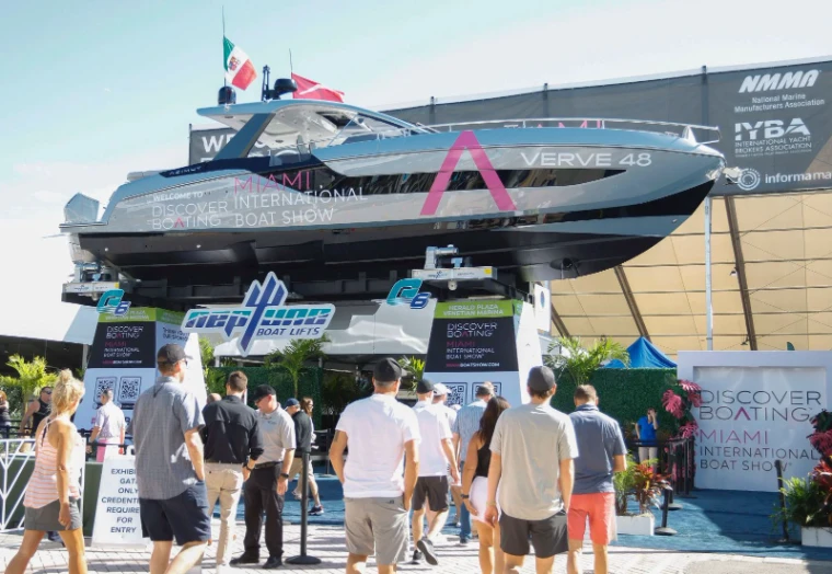 A motor yacht raised on lifts above the entrance gates as visitors arrive at the Miami International Boat Show, Miami Beach, an engagement in the season calendar of The Mansa Court