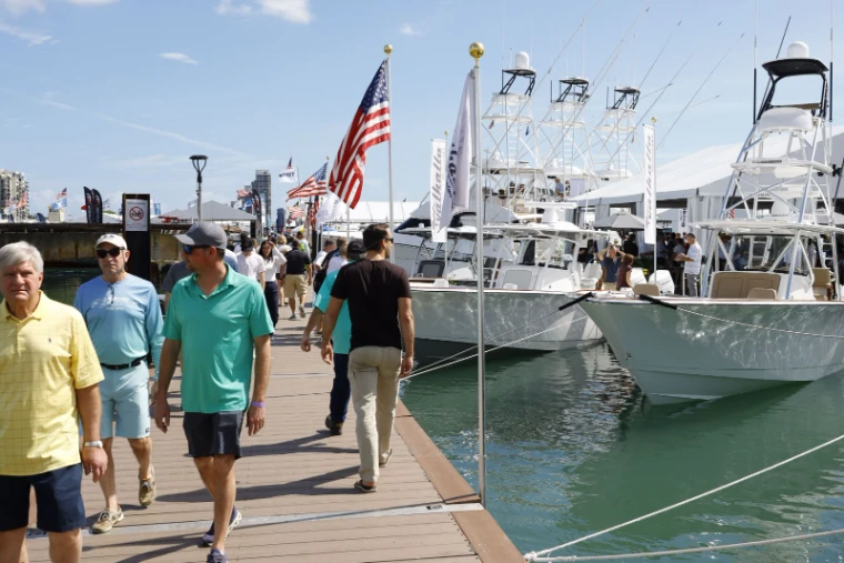 Visitors walking the in-water docks past sportfishing boats and tuna towers at the Miami International Boat Show, Miami Beach, an engagement in the season calendar of The Mansa Court