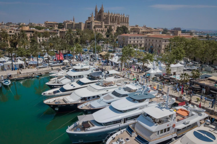 Superyachts berthed stern-to along the quay below the cathedral and the show pavilions at the Palma International Boat Show, Palma de Mallorca, a late-April engagement in the season calendar of The Mansa Court