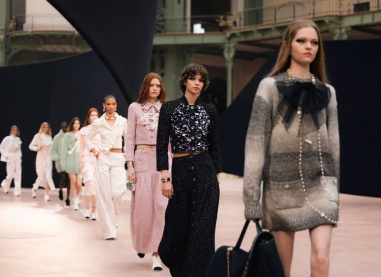 A long line of models in tweed, pearls and sequins walking in single file under the iron galleries of the Grand Palais at Paris Fashion Week, an engagement in the season calendar of The Mansa Court
