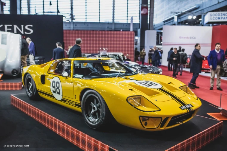 A yellow Ford GT40 in racing livery on a dealer stand at Rétromobile, Paris, an engagement in the season calendar of The Mansa Court