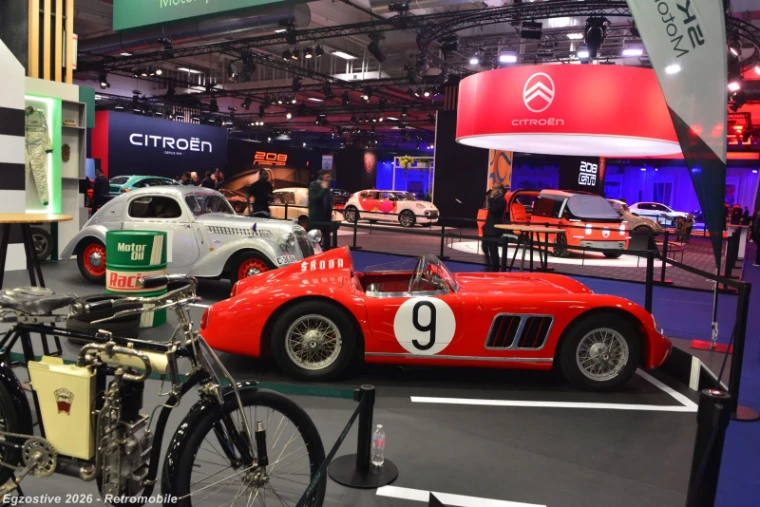 Marque stands and a red competition roadster in the manufacturer halls at Rétromobile, Paris, an engagement in the season calendar of The Mansa Court