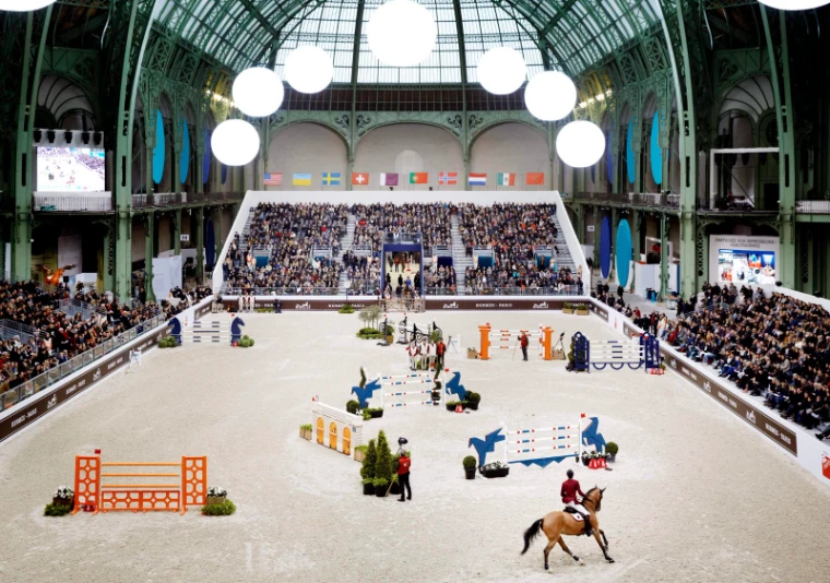 The jumping course laid out on the sand and the full grandstand seen from above at Saut Hermès, Grand Palais, Paris, an engagement in the season calendar of The Mansa Court