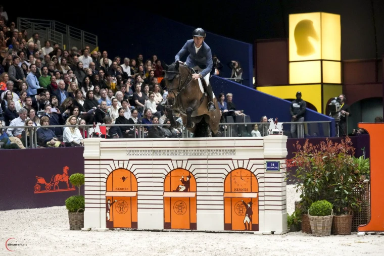 A horse and rider clearing the Hermès Faubourg shopfront fence at Saut Hermès, Paris, an engagement in the season calendar of The Mansa Court