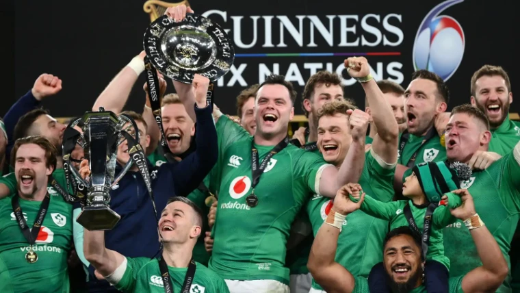 The Ireland squad in green raising the Championship trophy and the Triple Crown salver before the Guinness Six Nations backdrop, at Six Nations Championship, an engagement in the season calendar of The Mansa Court