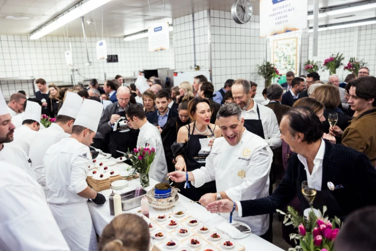 Guest chefs plating beetroot, smoked sardine and caviar for guests crowded into a hotel kitchen at the Kitchen Party of the St. Moritz Gourmet Festival, an engagement in the season calendar of The Mansa Court