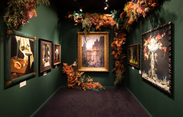 A green-walled dealer stand hung with paintings and dried flower installations at TEFAF Maastricht, an engagement in the season calendar of The Mansa Court