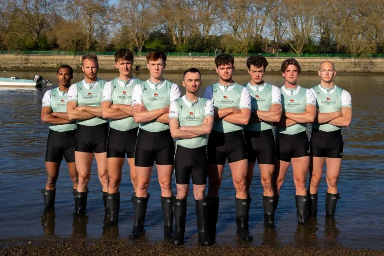 The Blue Boat crew photographed in the shallows of the Thames before The Boat Race, London, an engagement in the season calendar of The Mansa Court