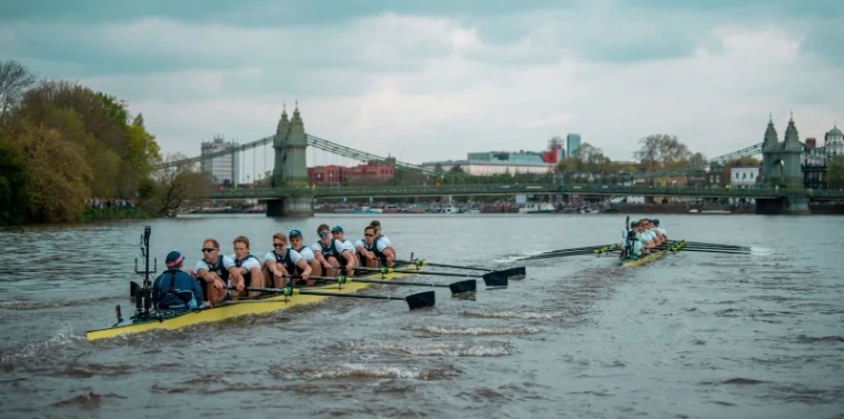 The two eights racing past Hammersmith Bridge on the Championship Course at The Boat Race, London, the spring fixture on the Tideway in the season calendar of The Mansa Court
