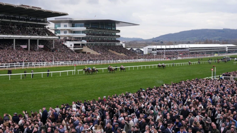 The grandstand and the crowd on the rail beneath Cleeve Hill during a race at The Cheltenham Festival, the March meeting in the season calendar of The Mansa Court