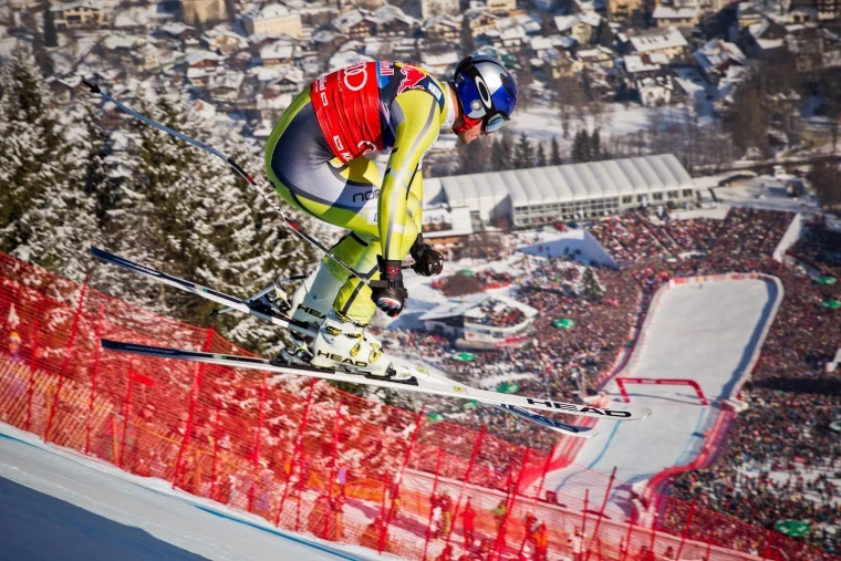 A downhill racer airborne on the Streif above the finish arena at the Hahnenkamm Races, Kitzbühel, an engagement in the season calendar of The Mansa Court
