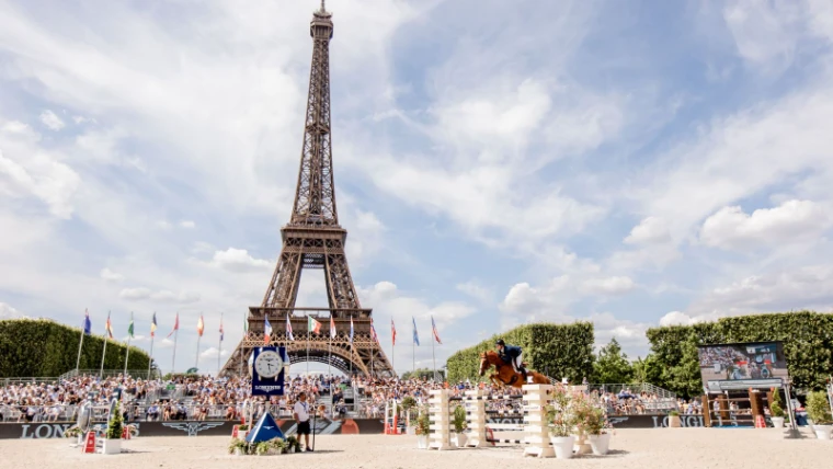 A dark horse and rider clearing the Longines oxer in the Paris arena at the Longines Global Champions Tour, an engagement in the season calendar of The Mansa Court