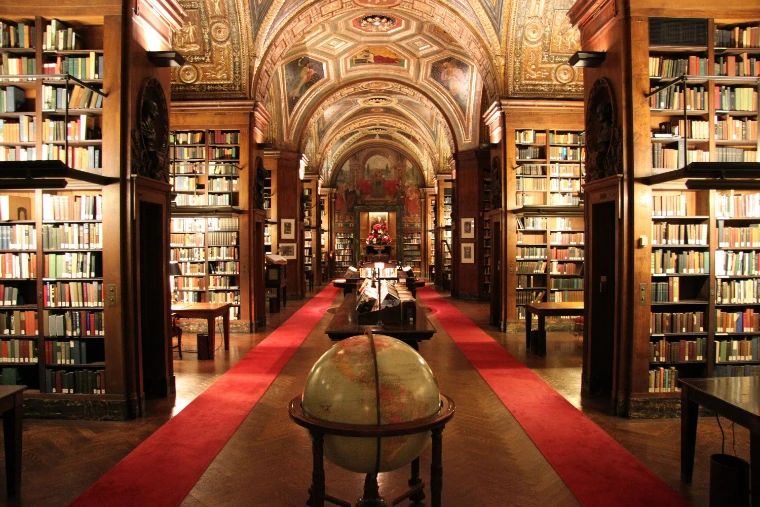 The vaulted, painted library of the University Club, with red runners leading between tall bookcases to a globe in the foreground (2010).