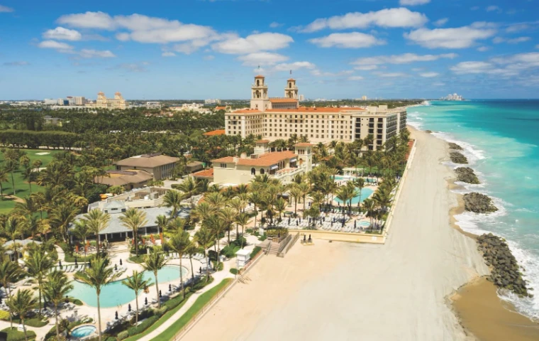 The Palm Beach oceanfront from above during The Palm Beach Season, the Atlantic on one side and the island’s towers on the other, an engagement in the season calendar of The Mansa Court