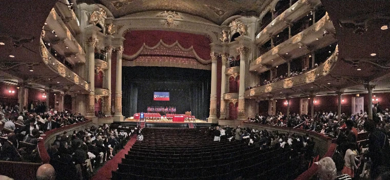 The red and gold auditorium of the Academy of Music, its tiers of boxes curving round to the stage, seen in a wide view (2017).