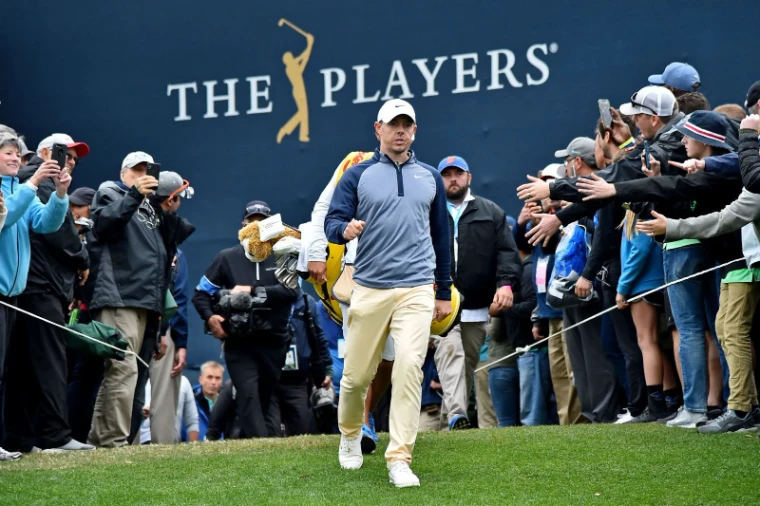 A player walking to the tee past the gallery and the tournament wall at The Players Championship, TPC Sawgrass, in the season calendar of The Mansa Court