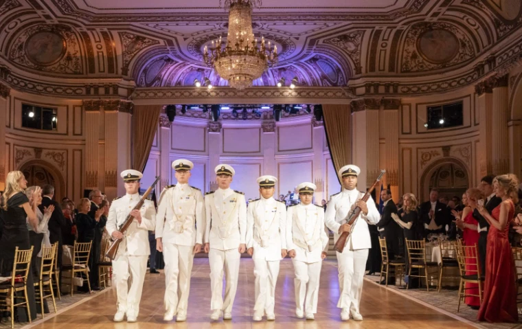 A naval colour guard in dress whites processes the ballroom to open The Quadrille Ball at The Plaza, New York, an engagement in the season calendar of The Mansa Court