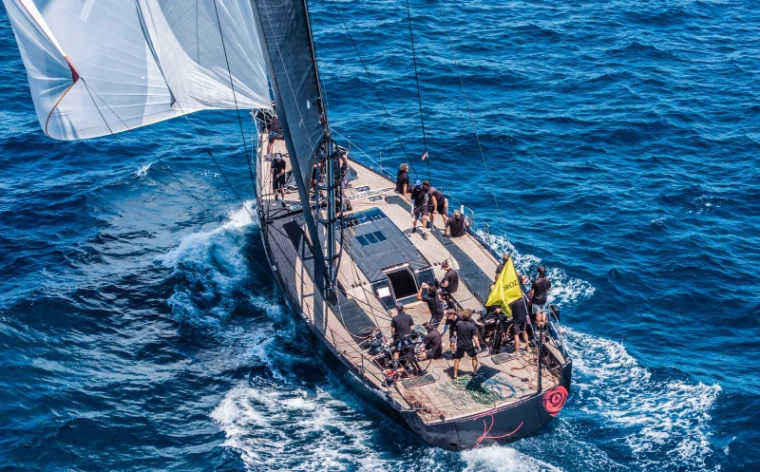 A sailing superyacht seen from above, crew working the afterdeck under way at The Superyacht Challenge, Antigua, English Harbour, an engagement in the season calendar of The Mansa Court