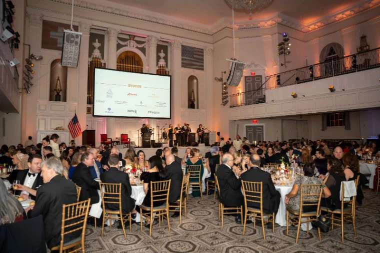 Guests at candlelit round tables during dinner in the ballroom at The Swiss Ball, the black-tie evening in New York in the season calendar of The Mansa Court
