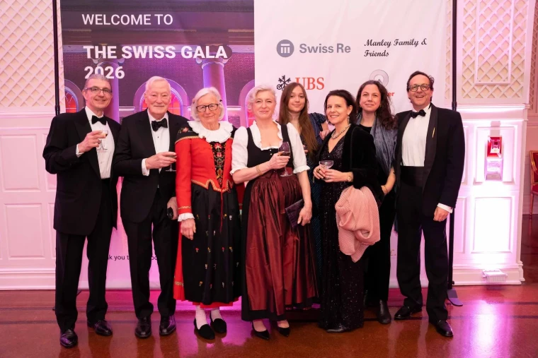 Guests in black tie and Swiss traditional dress raising a glass at the welcome to The Swiss Ball, New York, an engagement in the season calendar of The Mansa Court