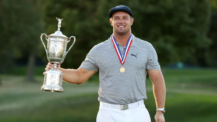 A champion wearing the gold medal and holding the silver US Open trophy in the evening light, the June major in the season calendar of The Mansa Court