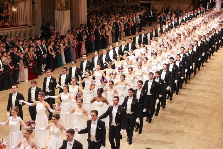 The opening committee entering in procession, debutantes in white with bouquets on the arms of partners in white tie, at The Vienna Opera Ball, an engagement in the season calendar of The Mansa Court