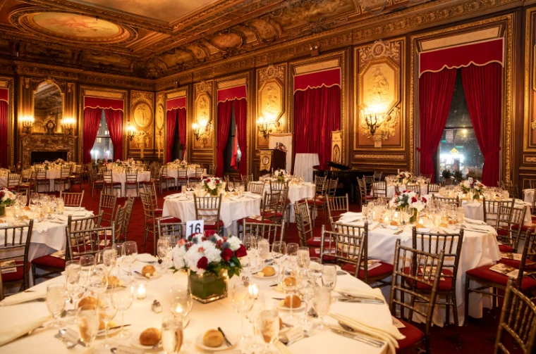 Guests in black tie at a numbered table of wheat and lilies during dinner at The Washington Birthday Ball, New York, an engagement in the season calendar of The Mansa Court