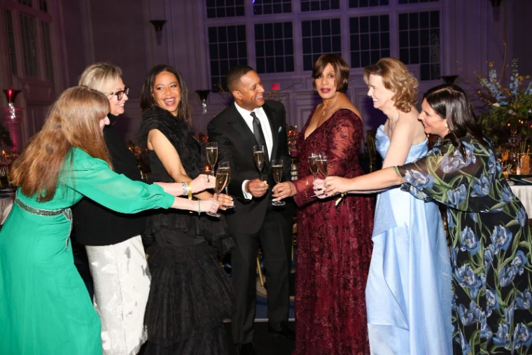 Guests in evening dress raising a champagne toast in the ballroom at The Winter Ball, New York, an engagement in the season calendar of The Mansa Court