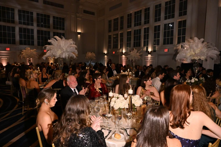 Guests at dinner under tall ostrich-plume centrepieces at The Winter Ball, New York, an engagement in the season calendar of The Mansa Court
