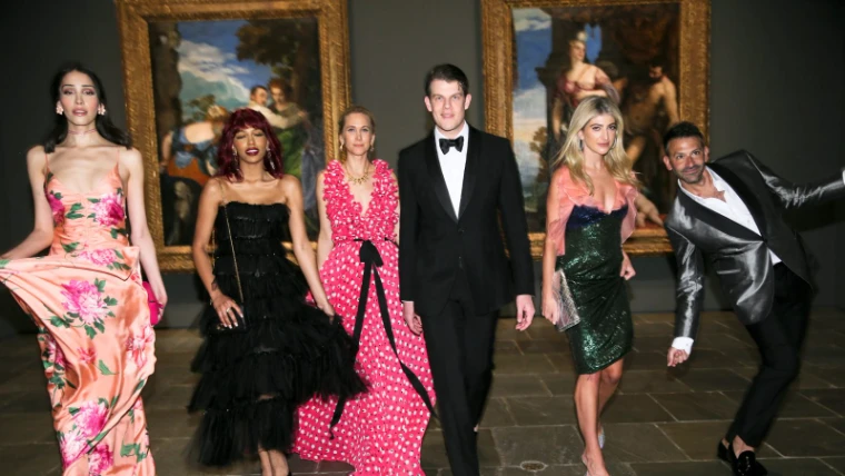 Guests in evening gowns and black tie walking the Titian gallery at The Young Fellows Ball, The Frick Collection, an engagement in the season calendar of The Mansa Court