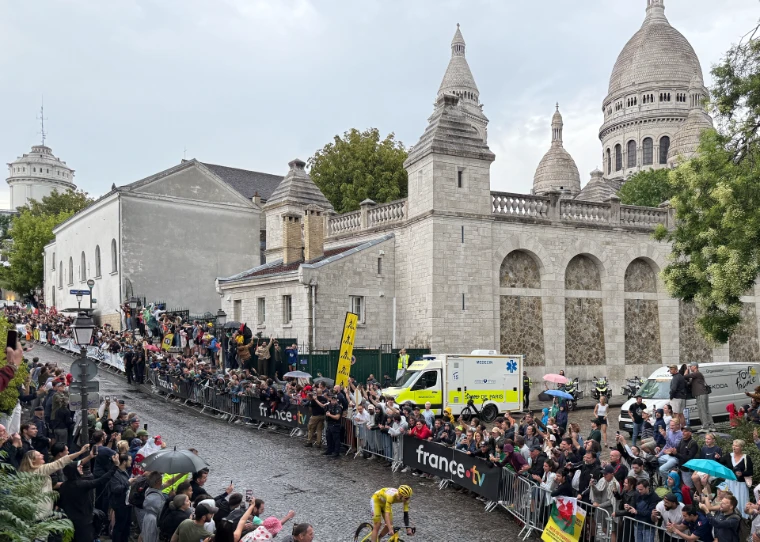 The yellow jersey climbs through the crowds below the Sacré-Cœur on the final stage (2025).