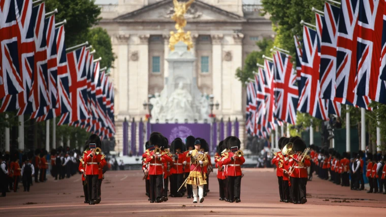 A Guards band marches down the flag-lined Mall from Buckingham Palace (2022). Trooping the Colour on Horse Guards Parade, London, in the season calendar of The Mansa Court