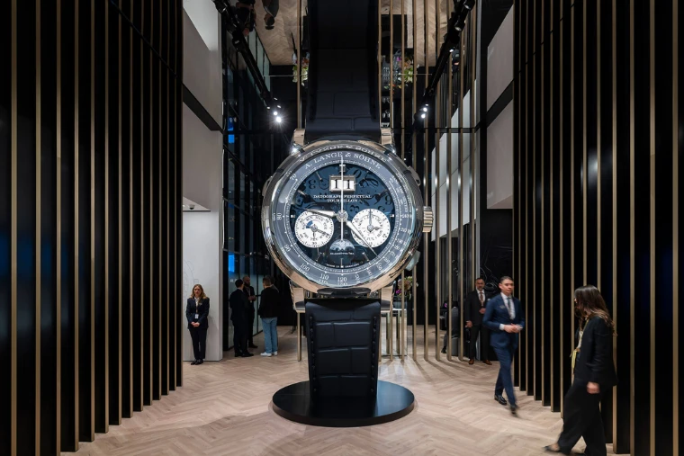 A giant A. Lange & Söhne Datograph Perpetual Tourbillon standing between the slatted walls of the Lange stand at Watches and Wonders Geneva, an early-April engagement in the season calendar of The Mansa Court