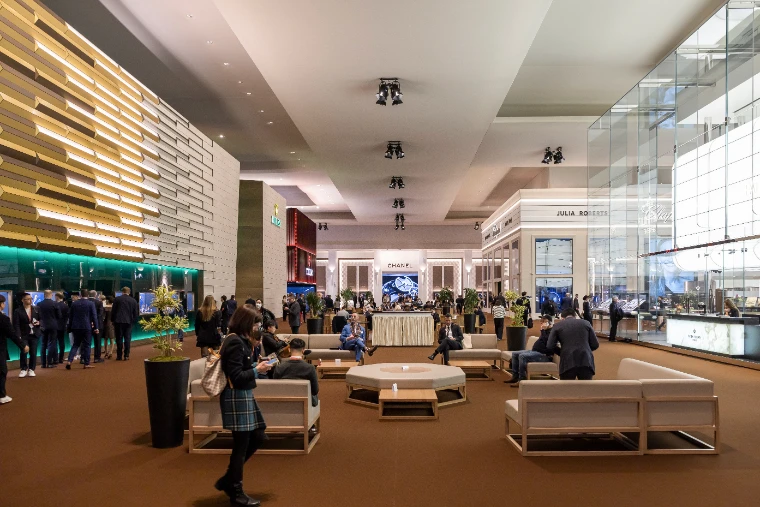 Visitors in the lounge of the Palexpo hall between the Rolex, Chanel and Patek Philippe stands at Watches and Wonders Geneva, an early-April engagement in the season calendar of The Mansa Court