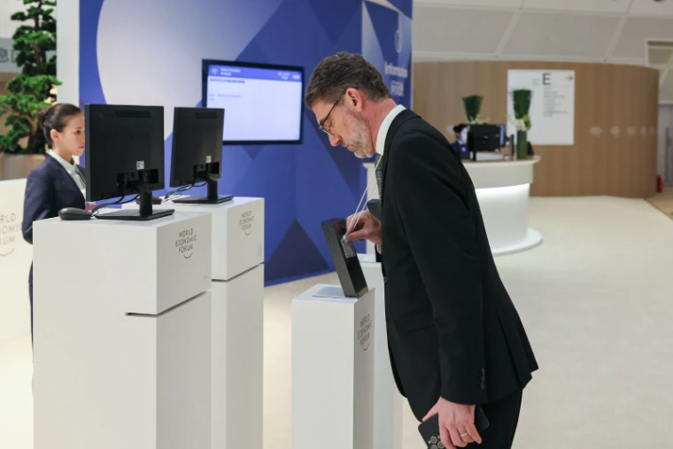 A participant collecting his badge at the registration desk at Davos, at World Economic Forum, an engagement in the season calendar of The Mansa Court